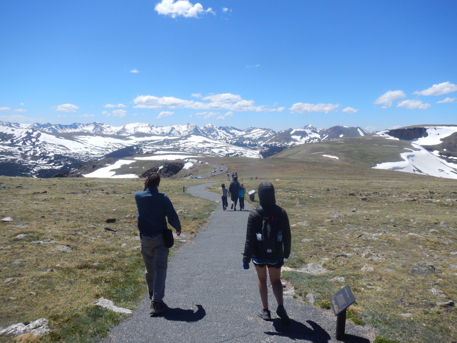 The whole family at the highest point in Rocky Mountain National Park with mountains all around