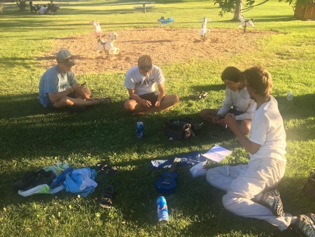 The team resting in the shade of a tree in the park