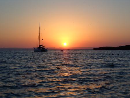 Dusk on the beach with a boat in the background