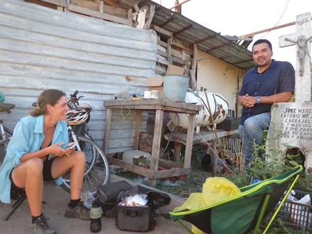 Ruth and Óscar talking next to a small tombstone by a roadside stall