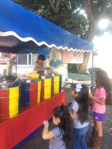 Icecream stall with three exited girls waiting for their treat