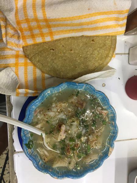 A dish of menudo with tortilla