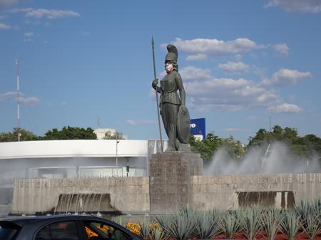 The Roman goddess of wisdom wearing a face mask in the centre of the roundabout with water fountains all around