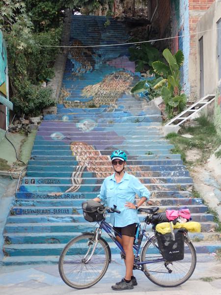 Ruth at the foot of a mural painted on some stairs in the town of Chapala