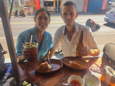 Ruth and Rob finally enjoying some tortas ahogadas (drowned baps) on the roadside with beer and michelada