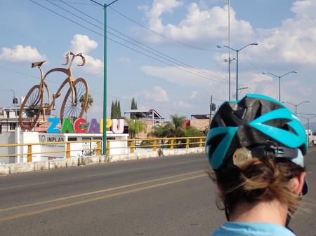 A welcome to town with a monument of a bicycle