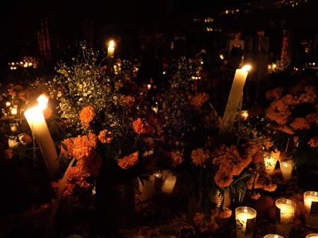 Cemetery with flowers and candles during the night of Día de Muertos