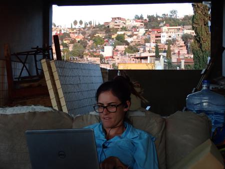 Ruth editing the podcast on the laptop with views of the mountain framed in the window in the background