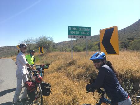 Rob, Gus and Óscar posing with a signpost marking a change of state from Querétaro to Hidalgo