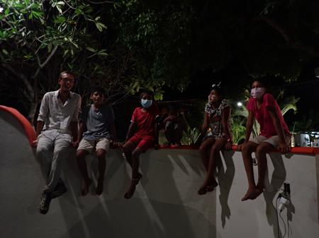 Rob sat on a wall at night with a bunch of local kids in Santa María Colotepec